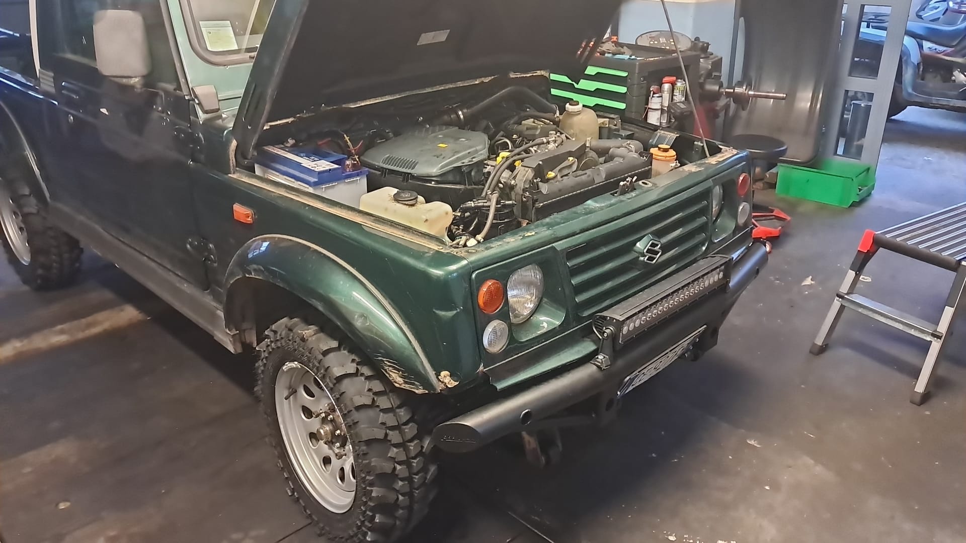 Geländewagen mit offener Motorhaube in der Werkstatt